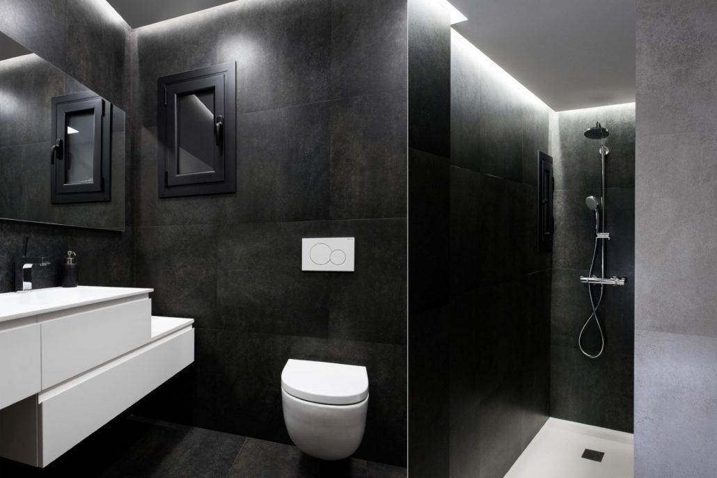 Zona de ducha del baño reformado en Vía Augusta, Barcelona, con revestimiento continuo por Lautoka Urbana