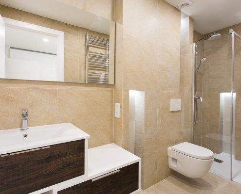 Baño en tonos beige reformado en Emancipació, Barcelona, con mueble suspendido por Lautoka Urbana
