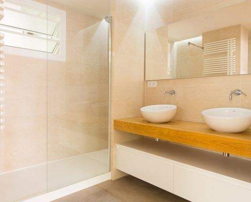 Baño blanco reformado en Emancipació, Barcelona, con ducha a ras de suelo por Lautoka Urbana