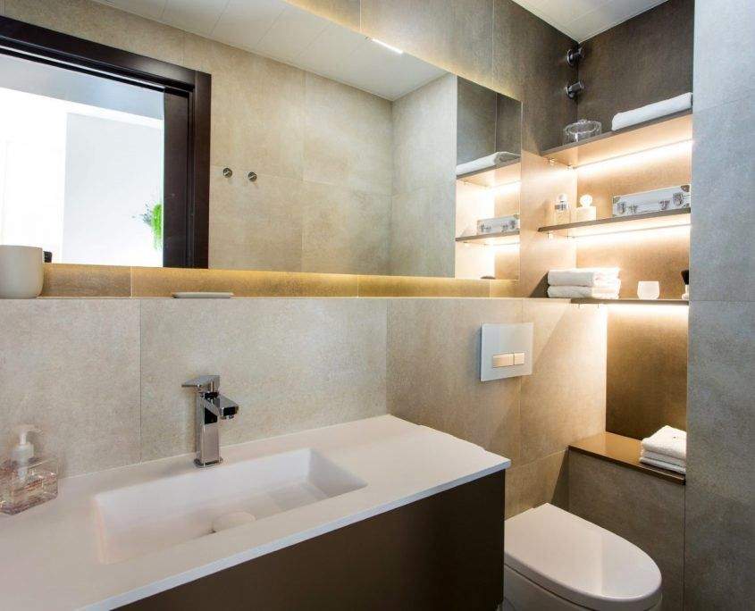 Baño reformado en Gràcia, Barcelona, con ducha a ras de suelo y espejo iluminado por Lautoka Urbana
