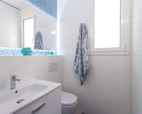 Baño en tonos azules reformado en la calle Marina, Barcelona, con ducha a ras de suelo por Lautoka Urbana