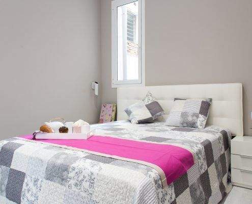Dormitorio suite reformado en la calle Marina, Barcelona, con tonos cálidos por Lautoka Urbana