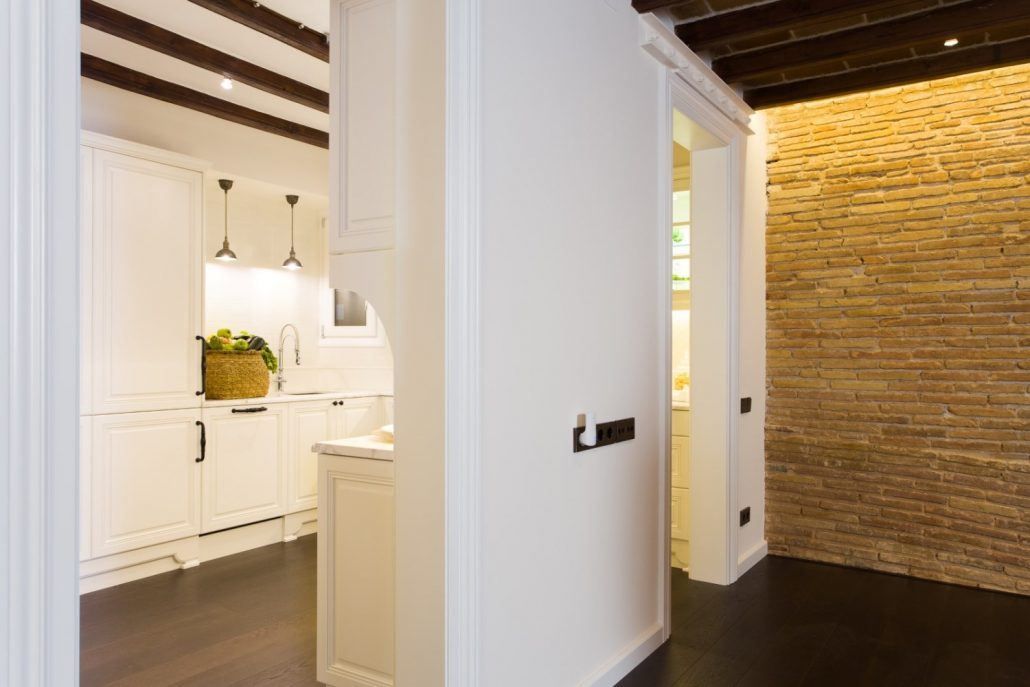 Salón reformado en el Born, Barcelona, con materiales cálidos e iluminación indirecta por Lautoka Urbana